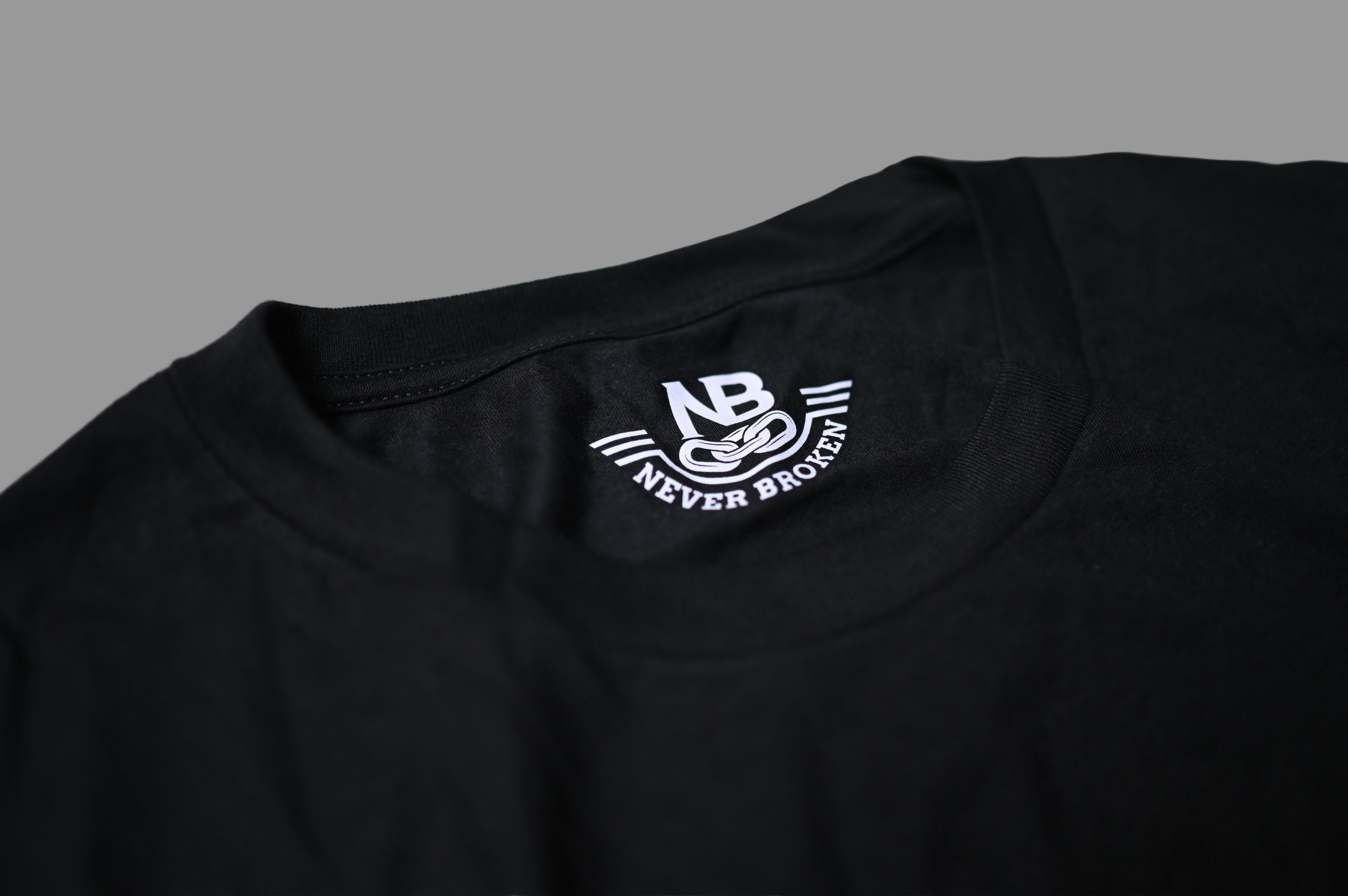 Black t-shirt with a white logo on a light gray background