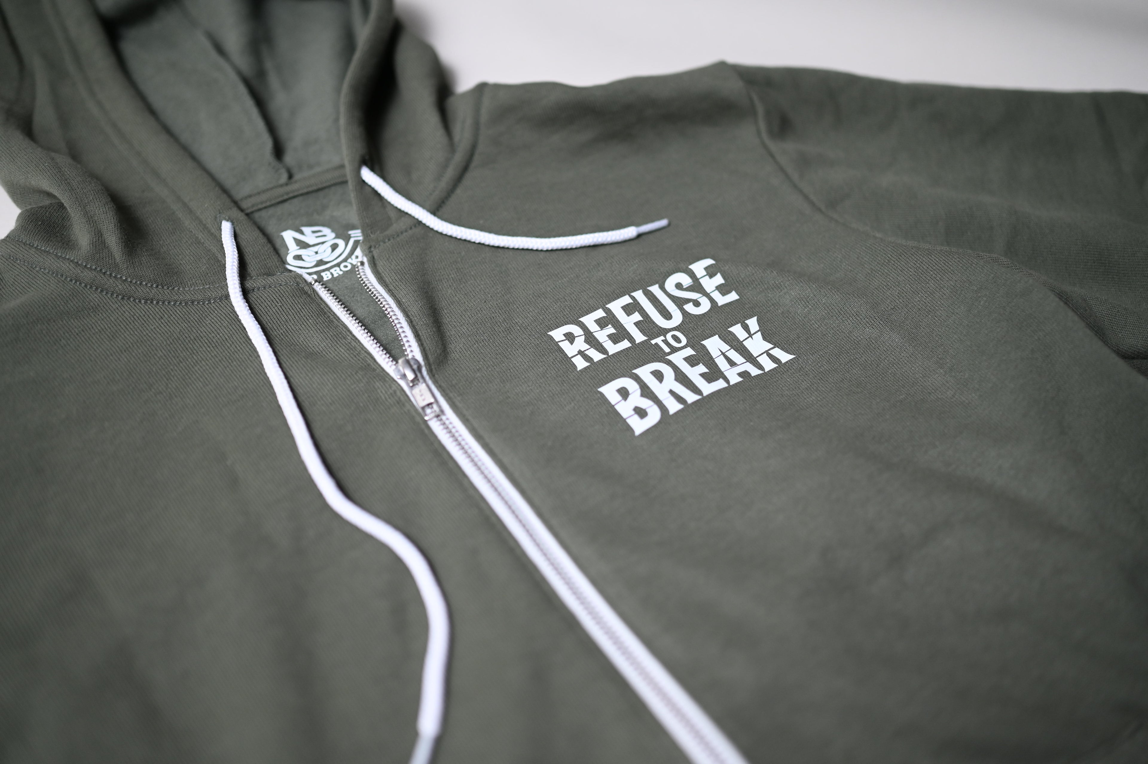 Green hoodie with 'Refuse to Break' text on a plain background