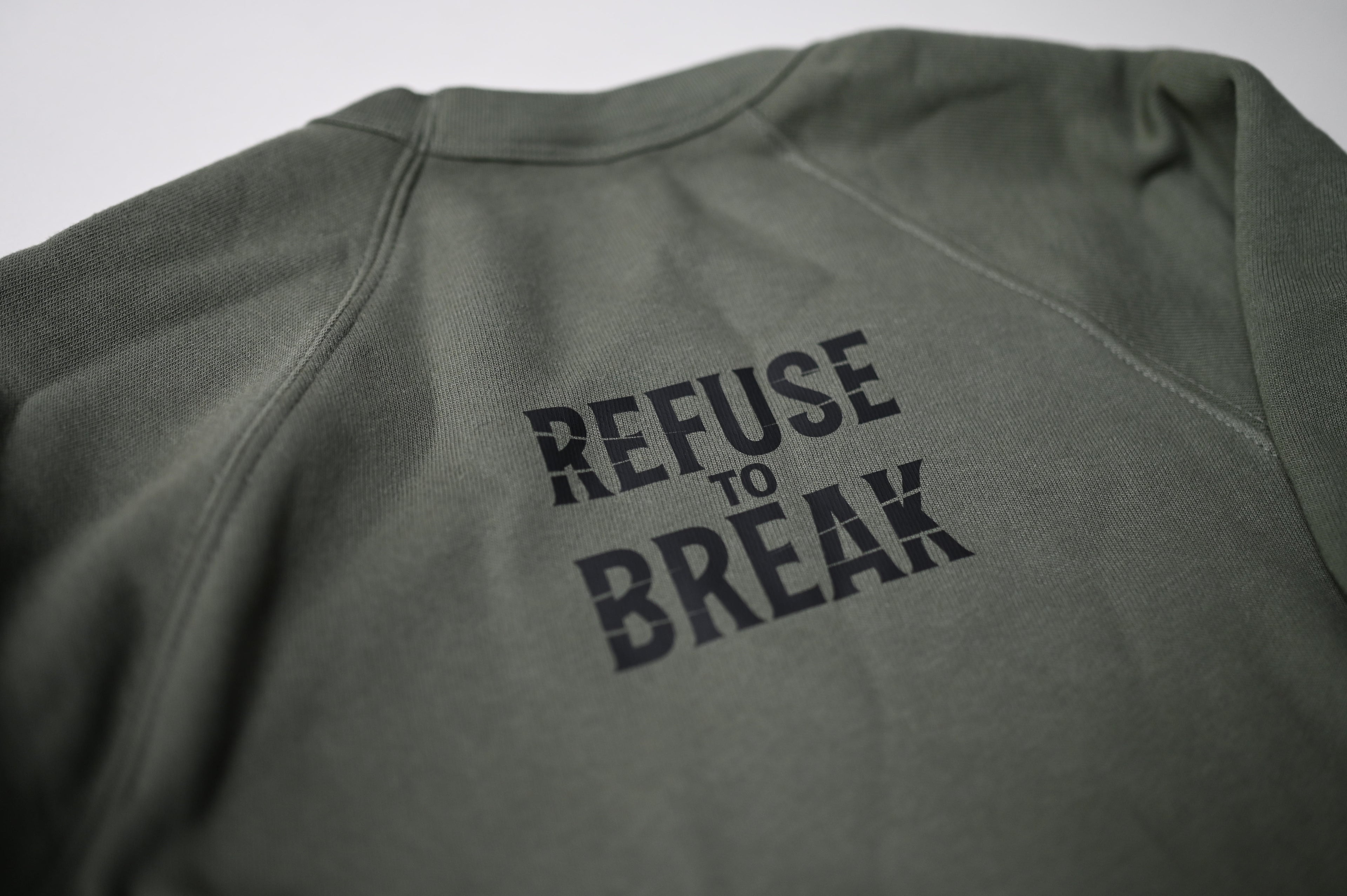 Green sweatshirt with 'REFUSE TO BREAK' text on a plain background