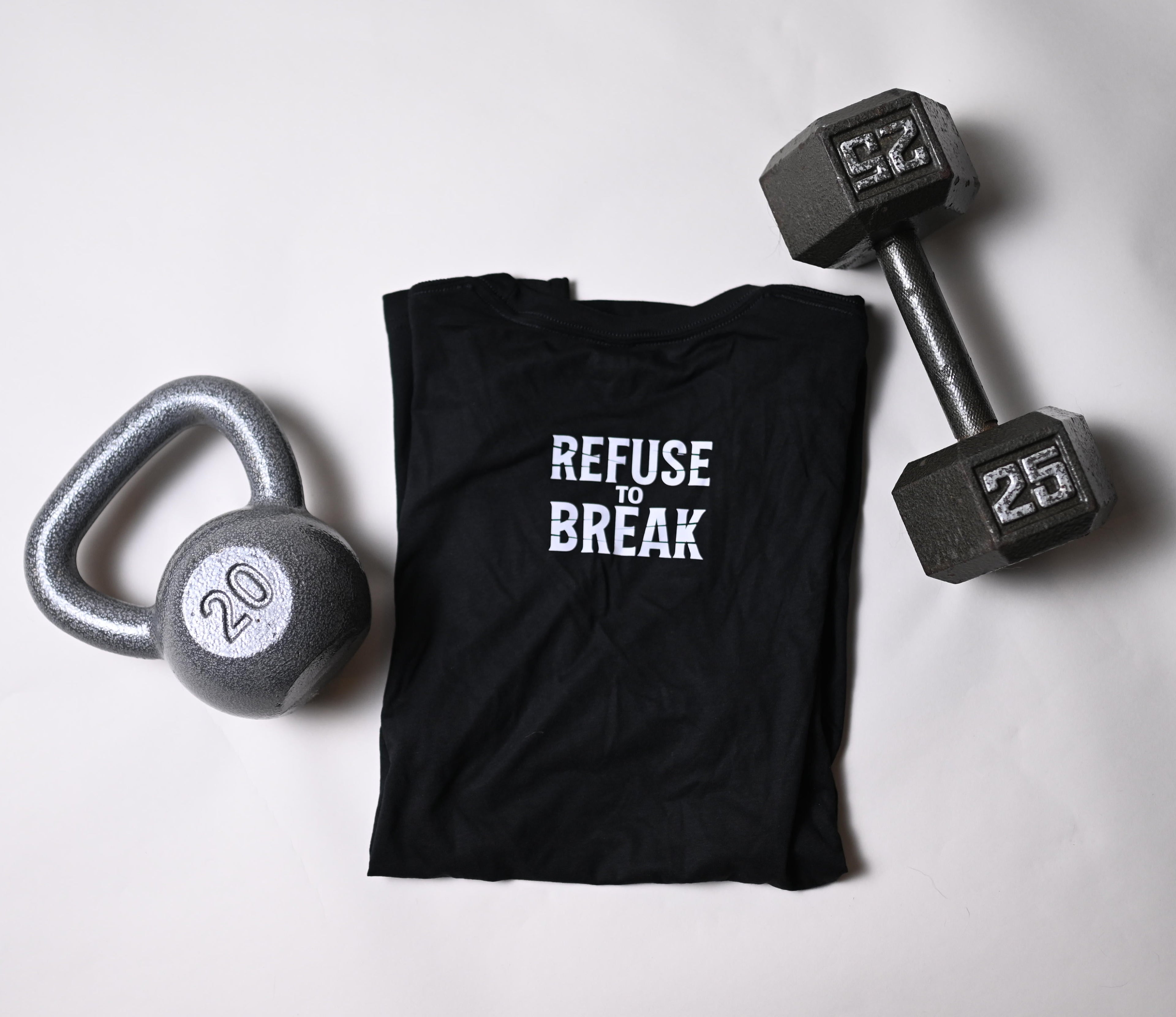 Black t-shirt with 'REFUSE BREAK' text, dumbbells, and kettlebell on a light gray background