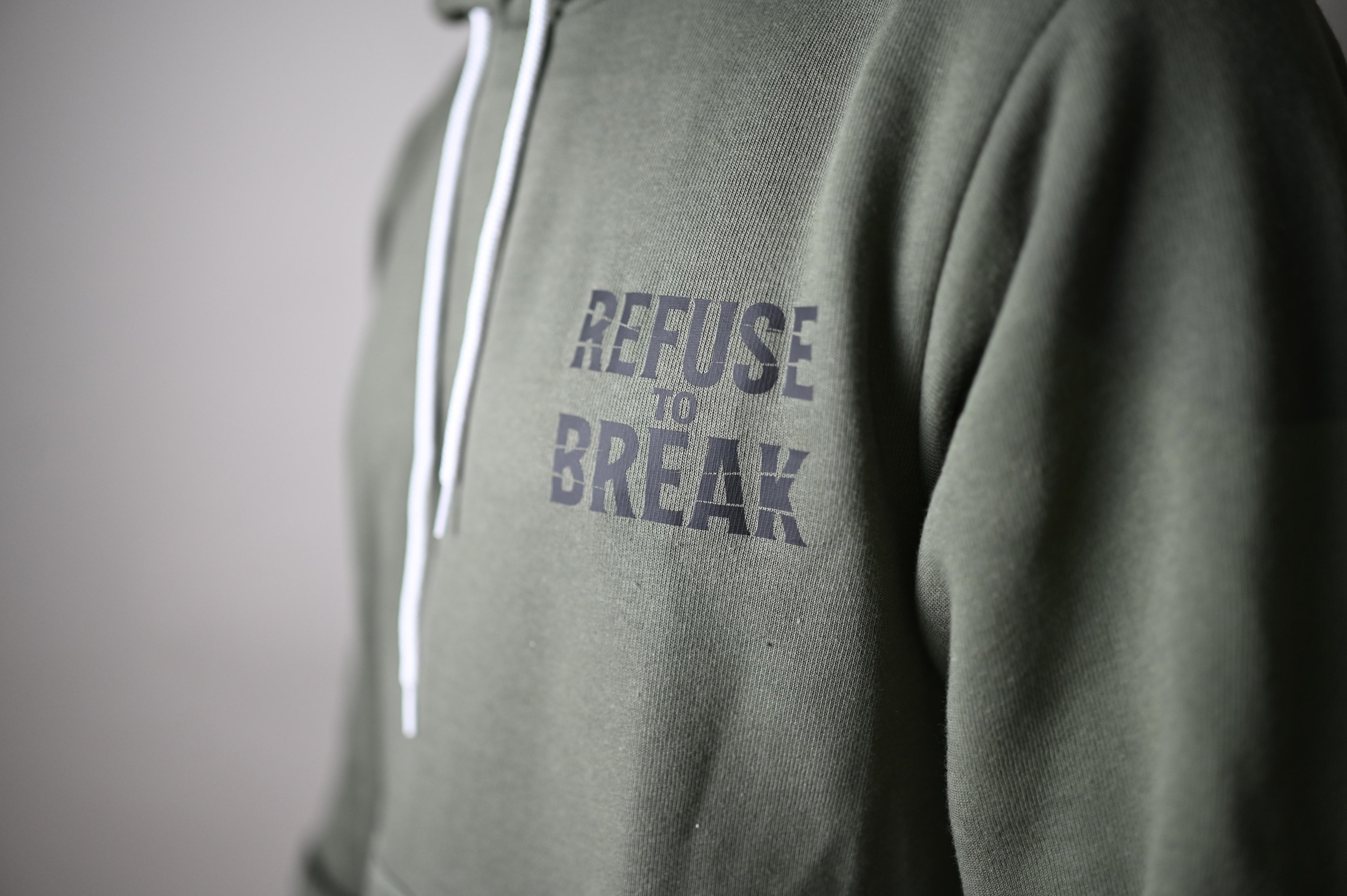 Green hoodie with 'Refuse to Break' text on a plain background