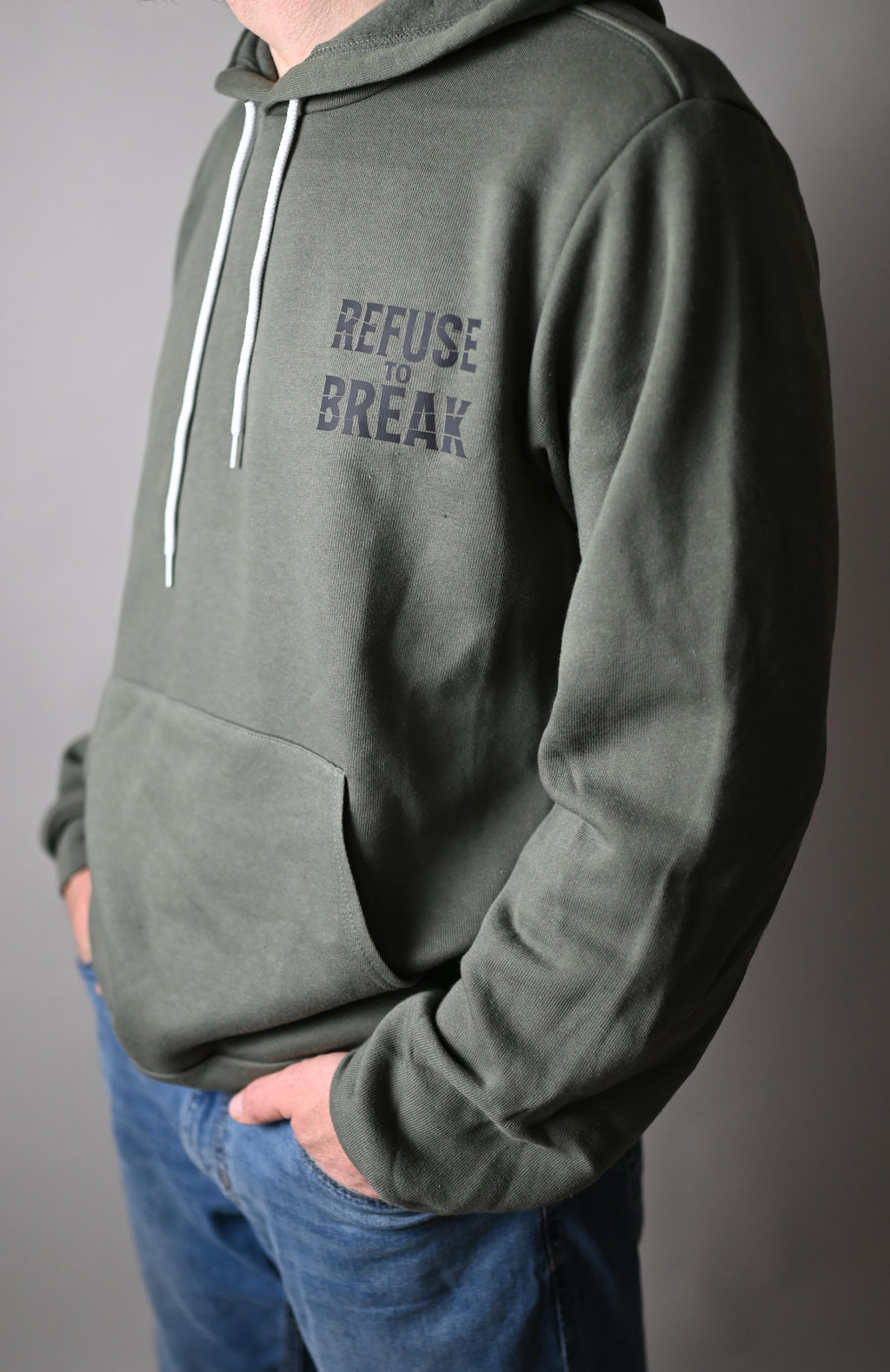 Person wearing a green hoodie with text on a gray background