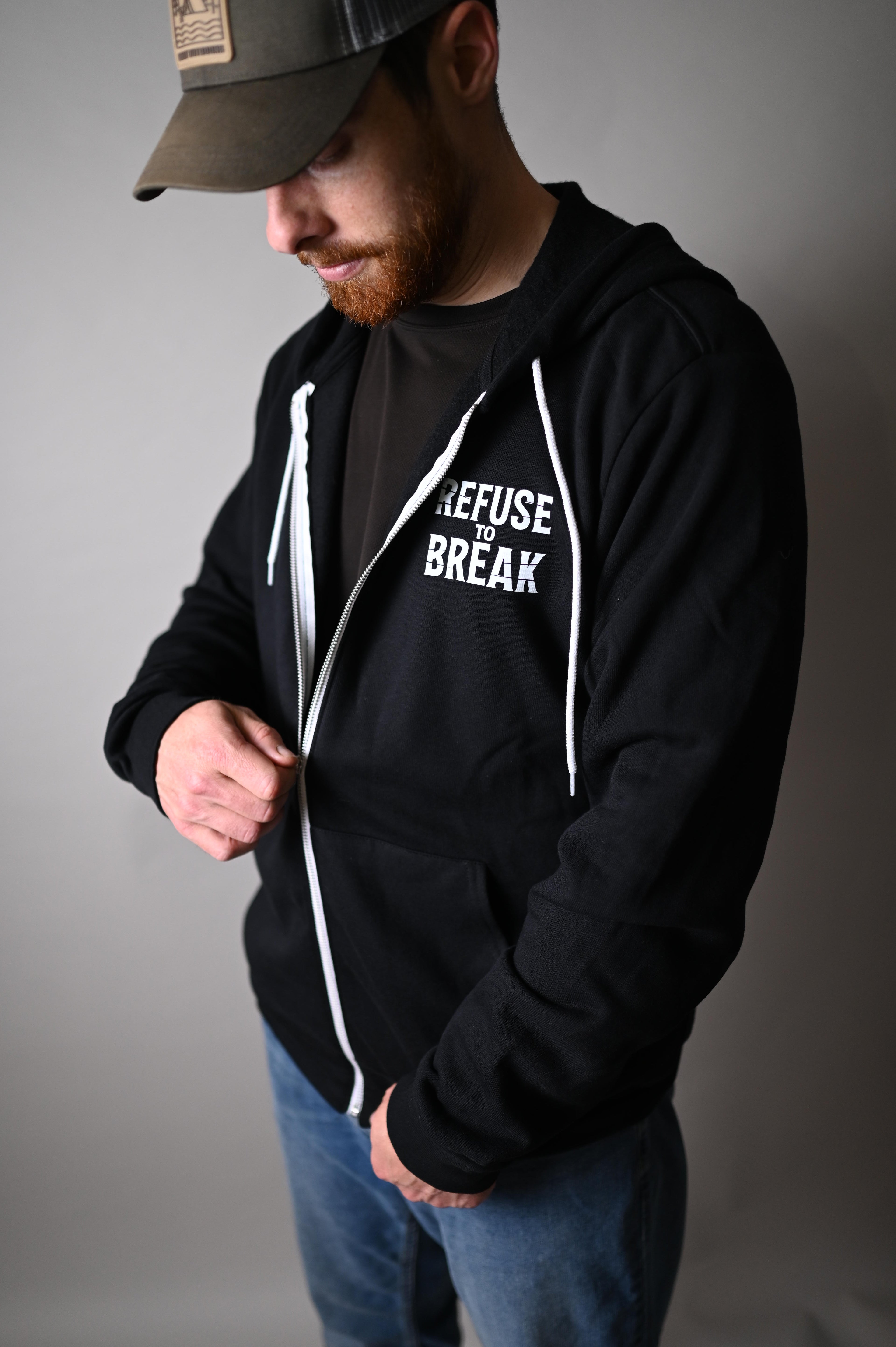 Person wearing a black hoodie with white text on a plain background