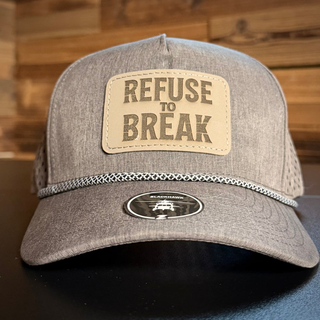 Gray cap with 'Refuse to Break' patch on a wooden background